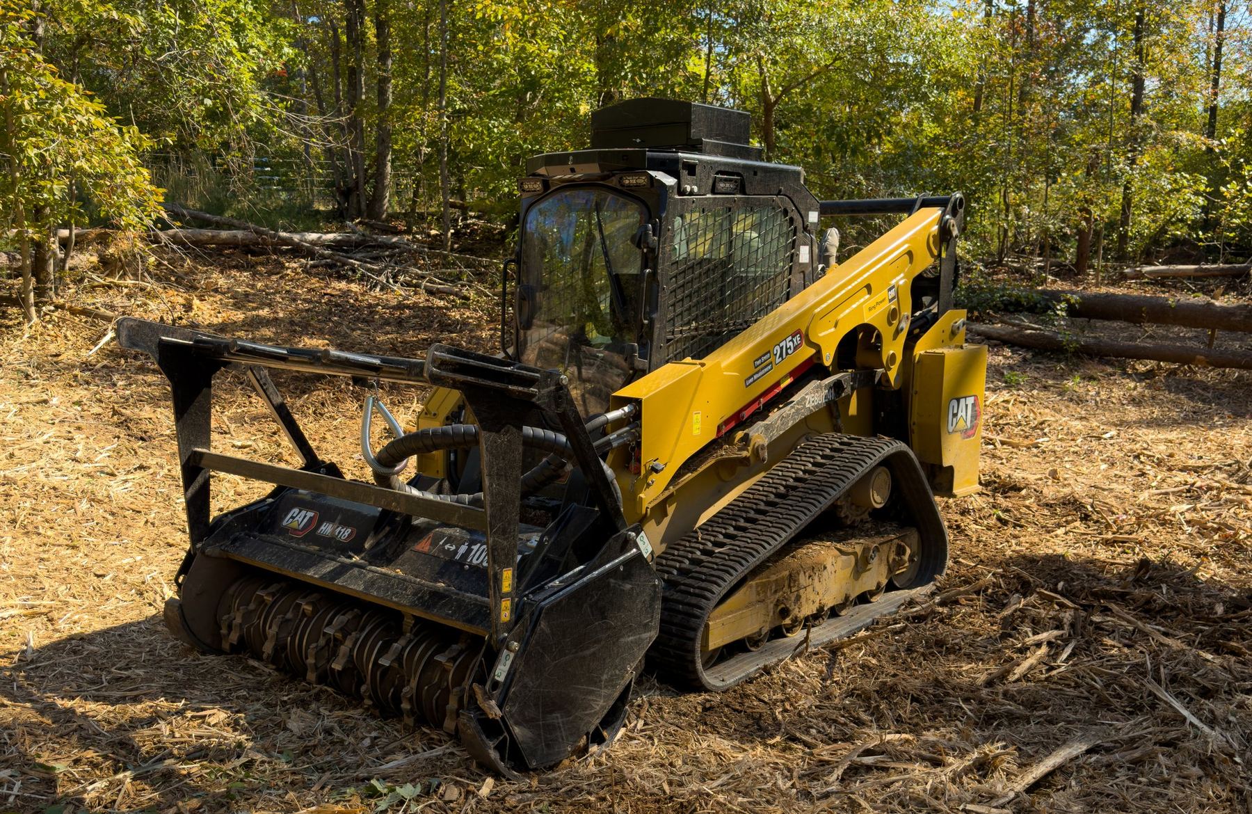 Skid steer mulcher working on a wooded property