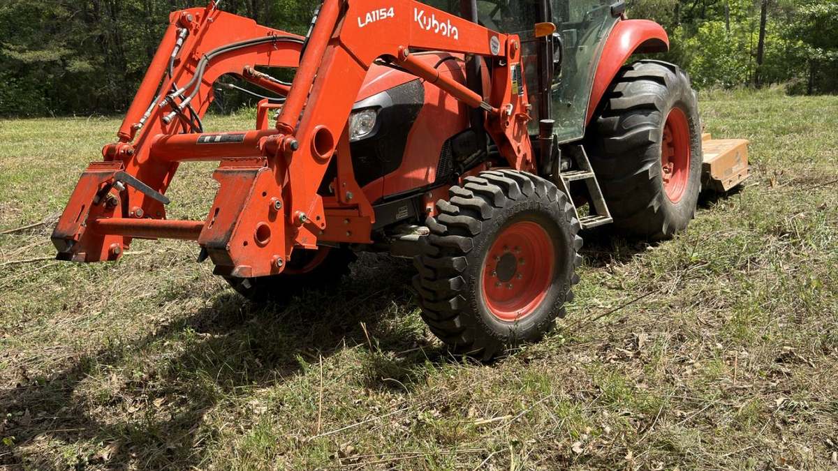 Kubota tractor with bush hog attachment for field mowing